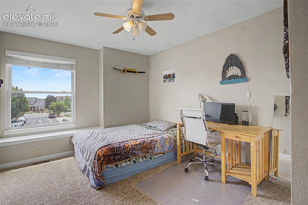 Image 30 of 45: Carpeted room with a ceiling fan, recessed window, and light-toned wall pai