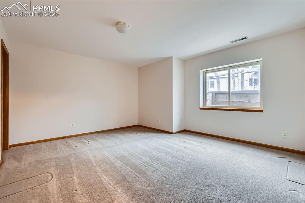 Image 24 of 31: Empty room with light colored carpet, visible vents, and baseboards