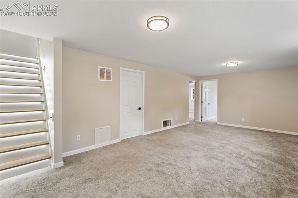 Image 40 of 50: Custom lighting on the stairs. New interior paint and new carpet in the bas