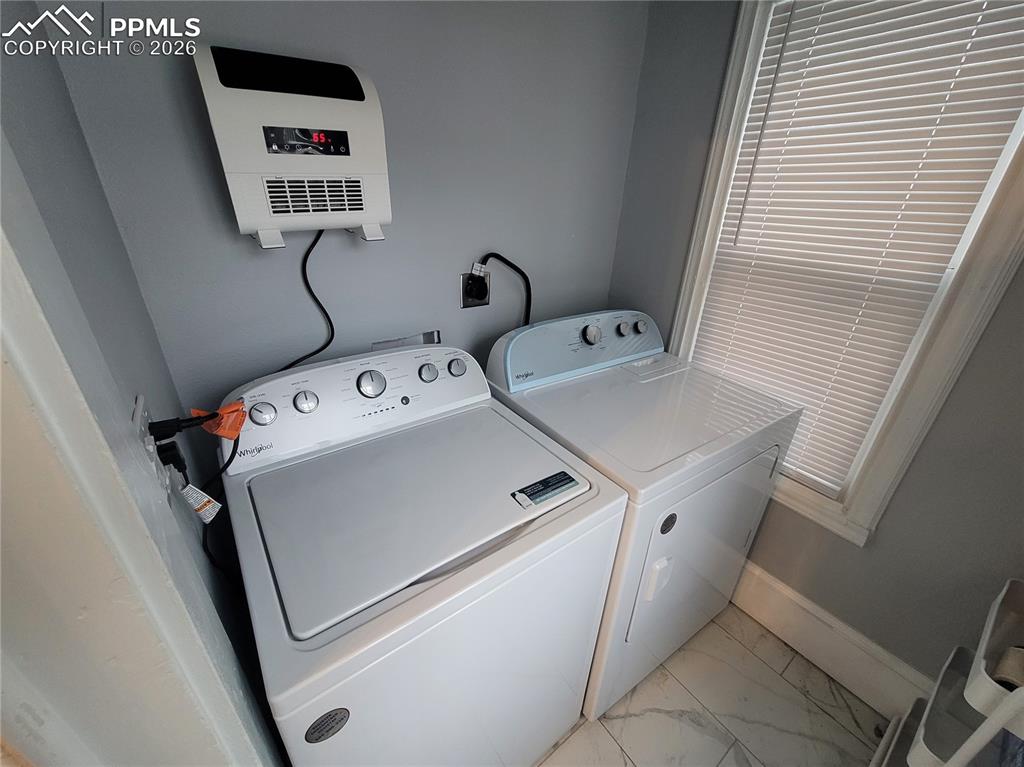 Image 11 of 21: Dedicated laundry area featuring a wall-mounted heater with digital display
