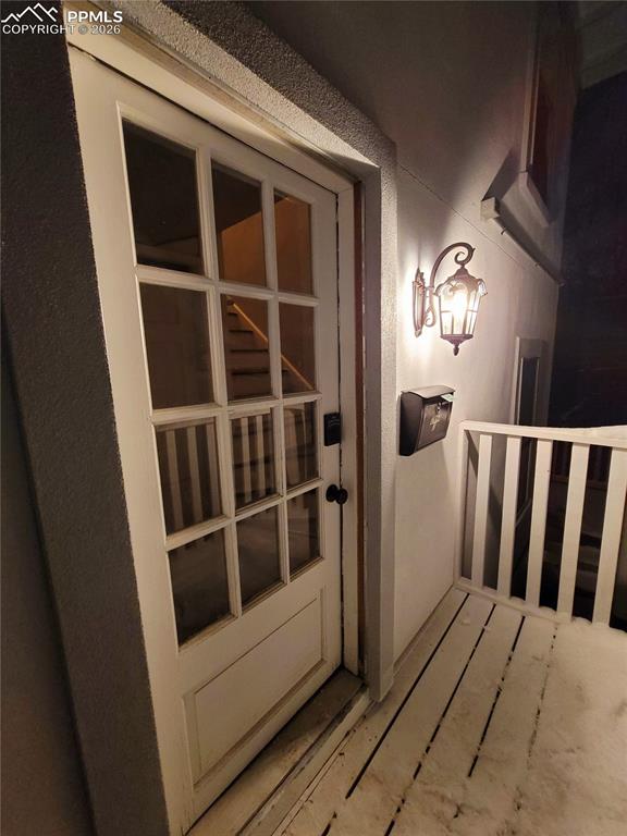 Image 12 of 21: Glass-paneled exterior door with a black knob and deadbolt