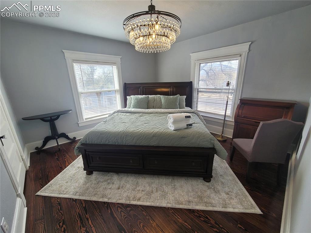 Image 15 of 21: Hardwood flooring complemented by a tiered crystal chandelier
