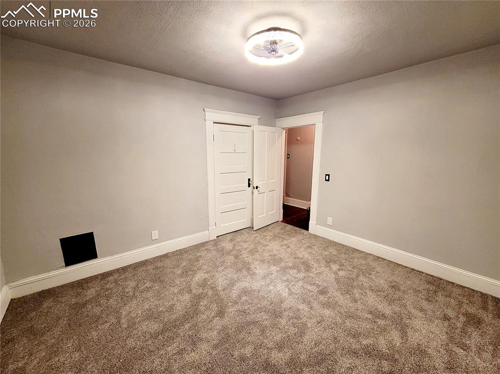 Image 17 of 21: Carpeted room with light gray walls and white trim