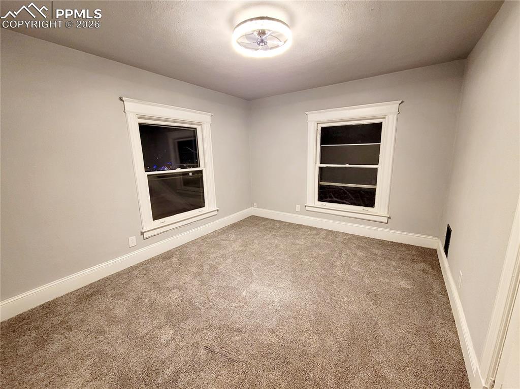Image 18 of 21: Room featuring two sash windows with white trim, light gray wall paint, tex