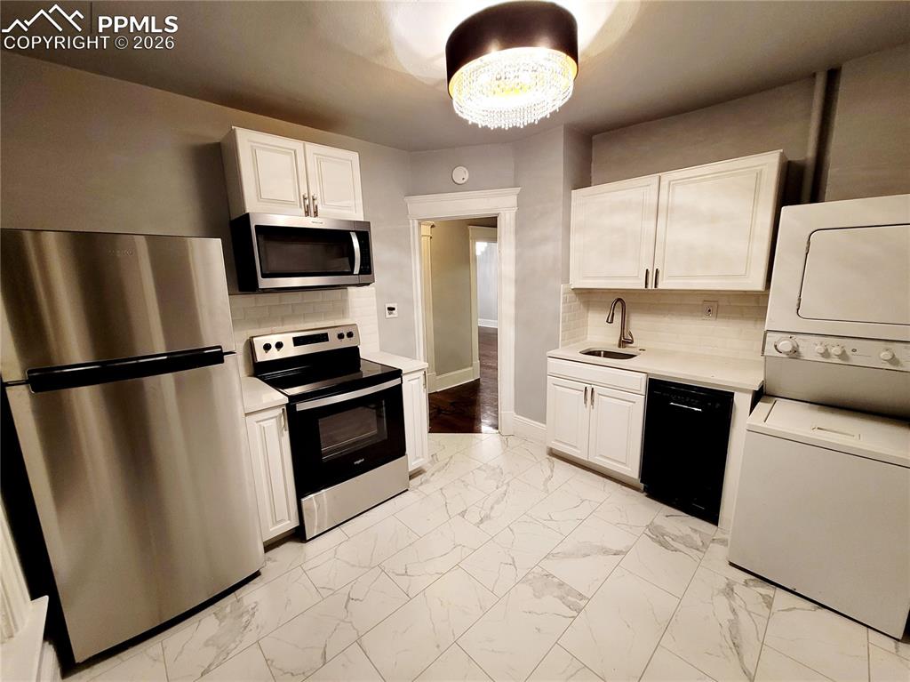 Image 19 of 21: Kitchen featuring white cabinetry, light-toned countertops, and a white sub
