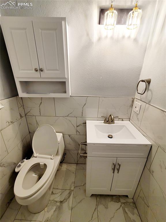 Image 21 of 21: Bathroom featuring a white vanity with integrated sink, white storage cabin