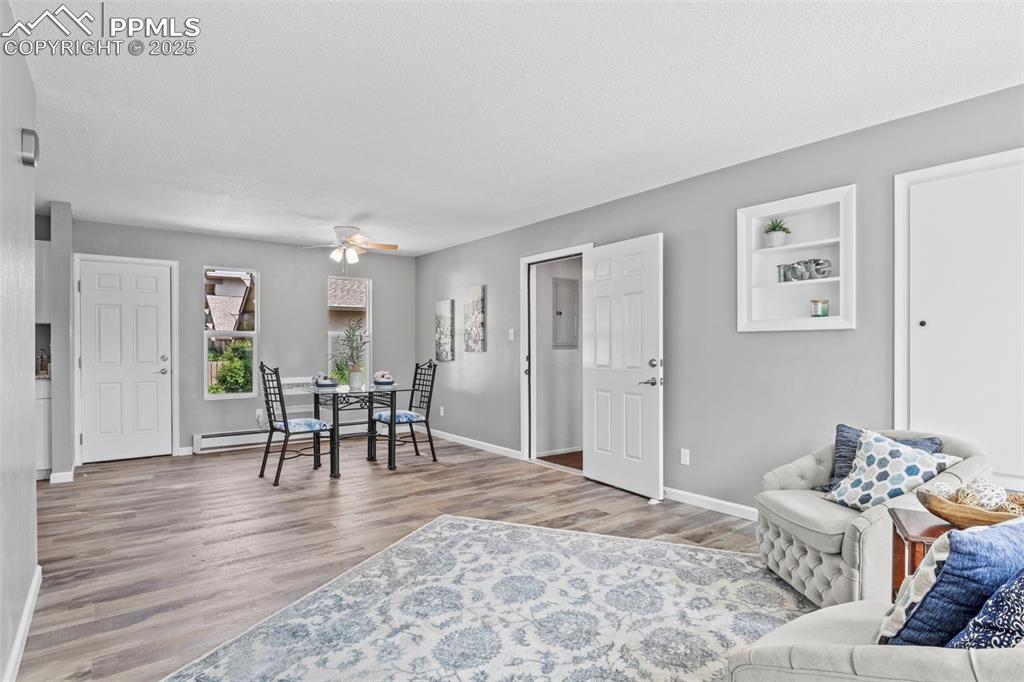 Image 10 of 44: Living room featuring wood finished floors, a ceiling fan, and a textured c
