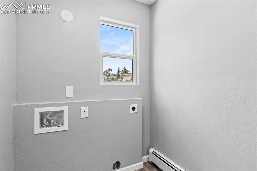 Image 11 of 44: Laundry room with electric dryer hookup, baseboard heating, and hookup for