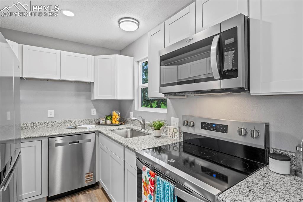 Image 15 of 44: Kitchen with all new appliances with stainless steel finishes, white cabin