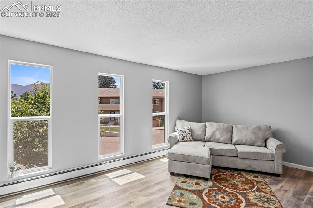 Image 24 of 44: Living room of F6 portion of Condo with windows and views of mountains