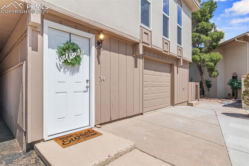 Image 4 of 44: Doorway to property with an attached garage and driveway