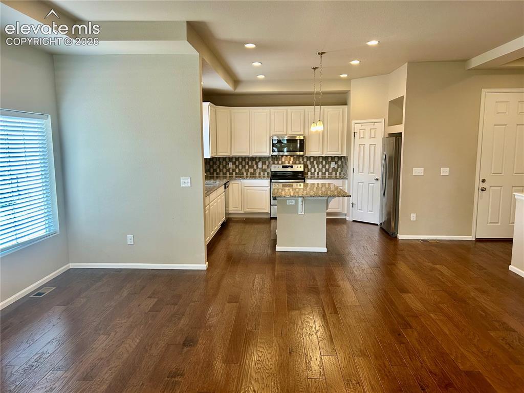 Image 13 of 38: view of the living, kitchen dining spaces from the deck entry