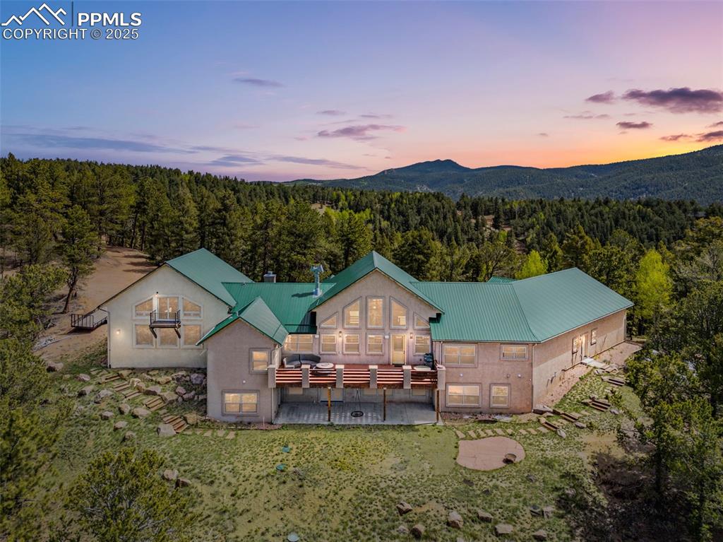 Image 2 of 47: View from above of property featuring a heavily wooded area and a mountain