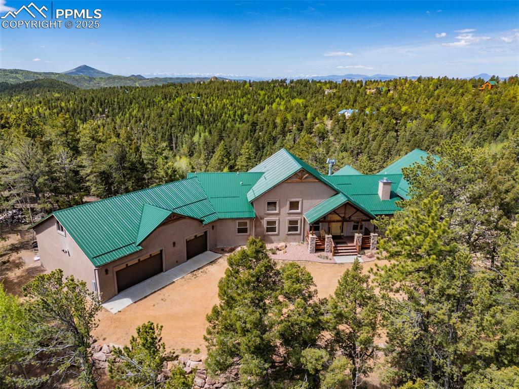 Image 4 of 47: Aerial view of property and surrounding area with a forest and a mountainou