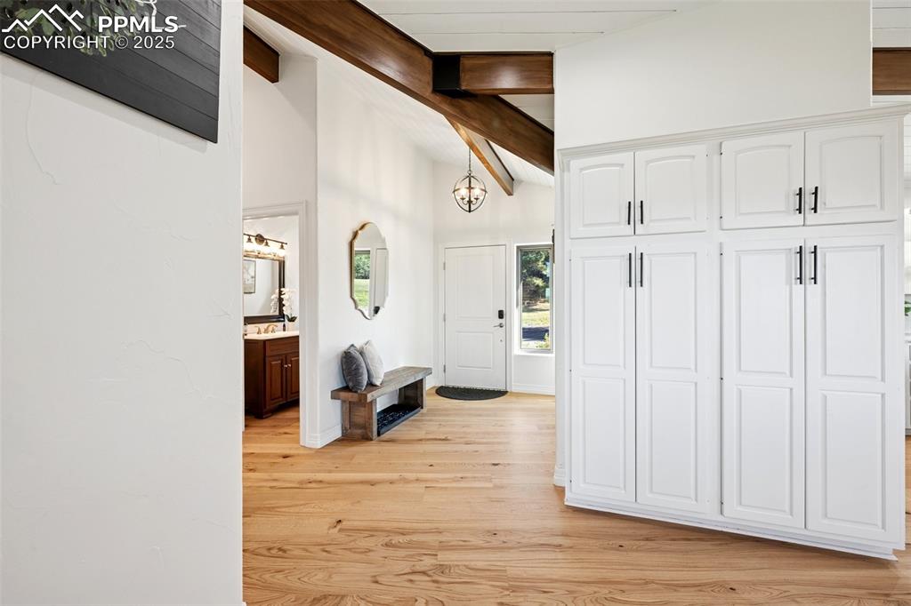 Image 3 of 49: Entryway with light wood-style floors and a chandelier