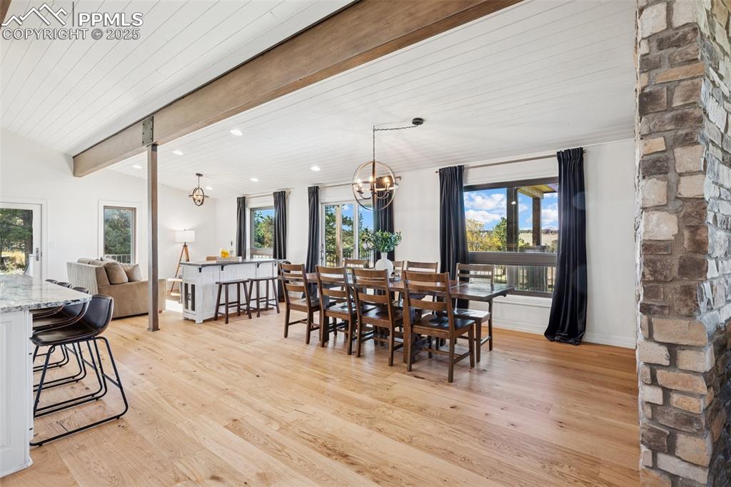 Image 4 of 49: Dining area featuring light wood-type flooring, a chandelier, and a wooden 
