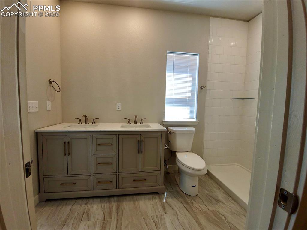 Image 28 of 47: Double vanity with quartz counters, undermount sinks, and walk-in shower wi