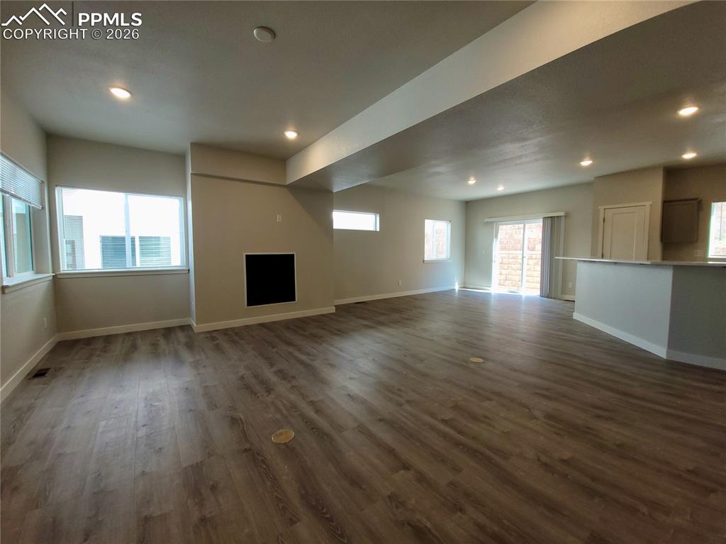 Image 6 of 47: Living area features durable LVP flooring and gas fireplace (example finish