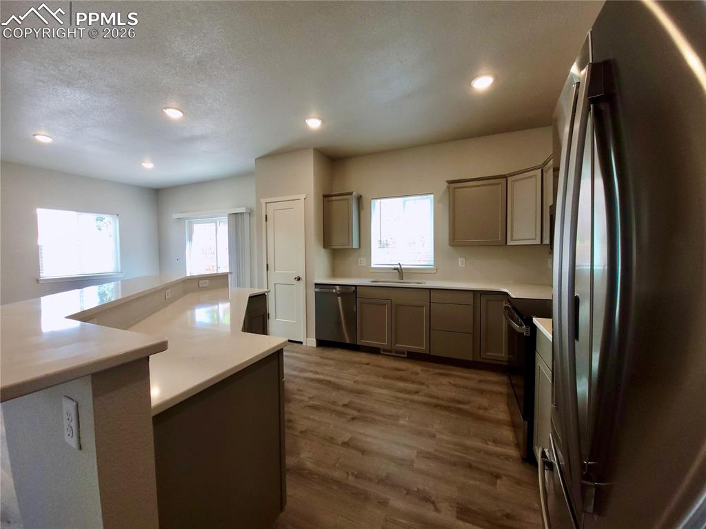 Image 8 of 47: Kitchen features 30" upper cabinetry, pantry, and stainless steel undermoun