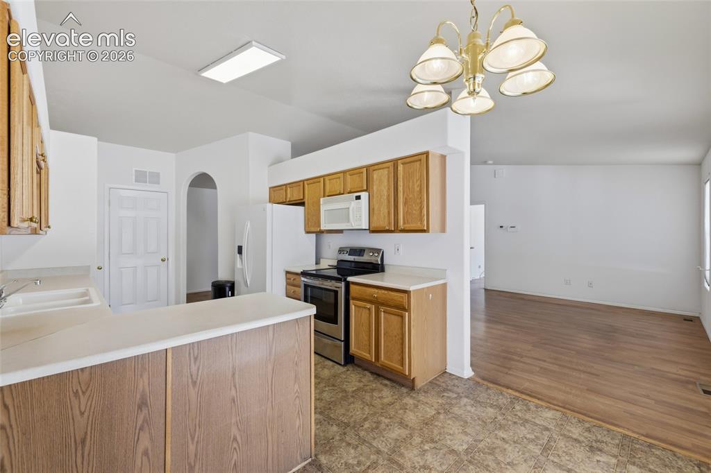 Image 14 of 45: Kitchen featuring wood cabinetry, laminate countertops, and stainless steel