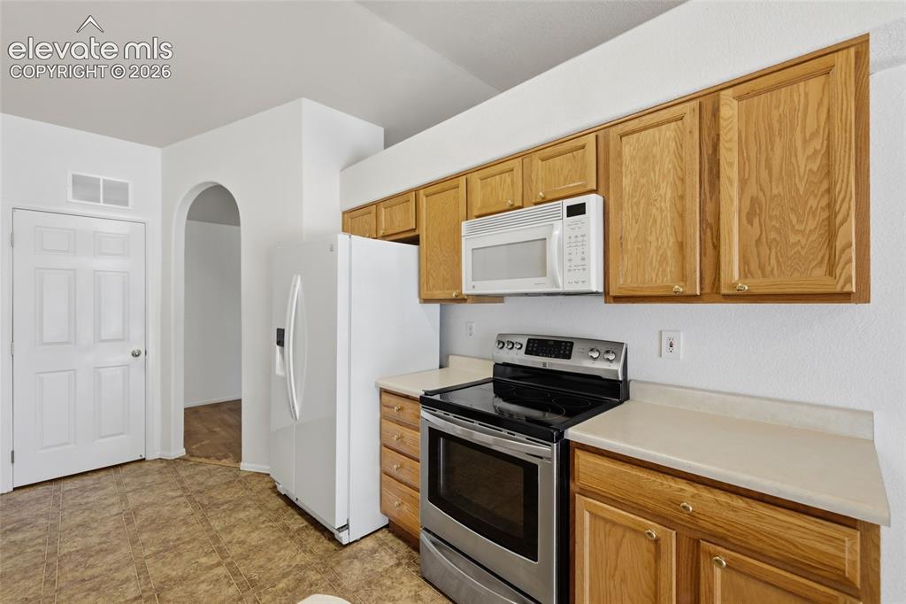 Image 19 of 45: Kitchen featuring wood cabinetry, a stainless steel range, a built-in micro
