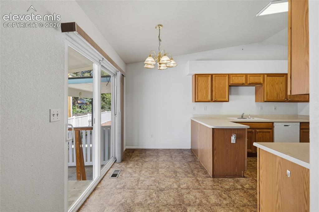 Image 20 of 45: Kitchen with wood cabinetry, laminate countertops, and a built-in dishwashe