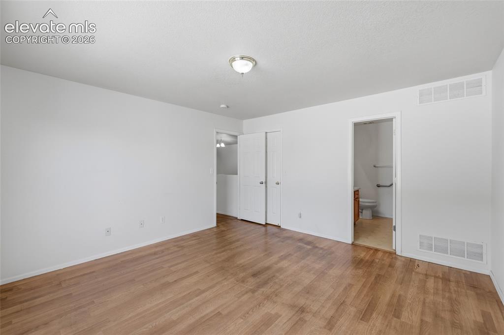 Image 23 of 45: Wood-finish flooring with white walls and a ceiling-mounted light fixture