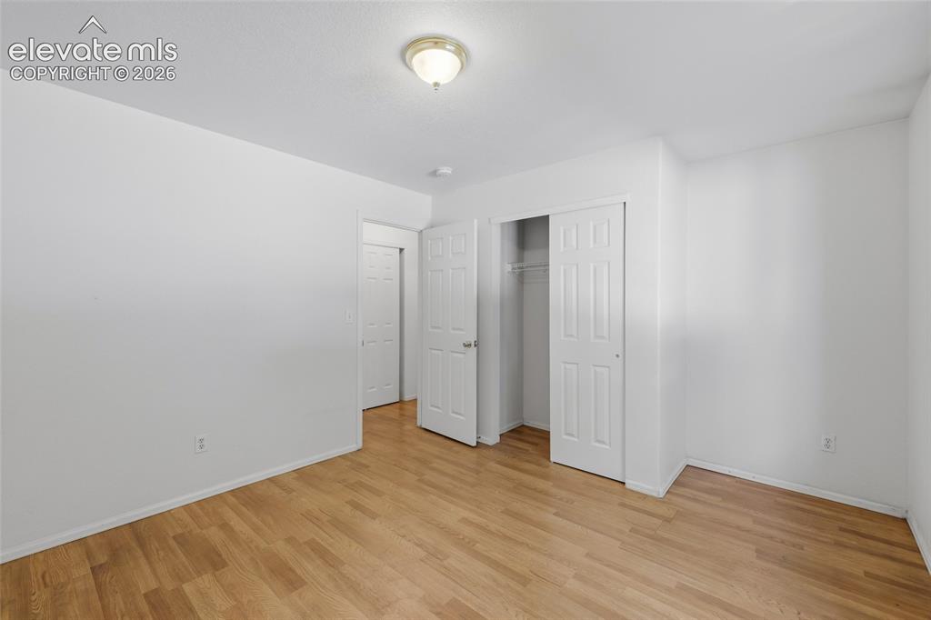 Image 29 of 45: Wood-finish flooring, white walls, ceiling-mounted light fixture, white int