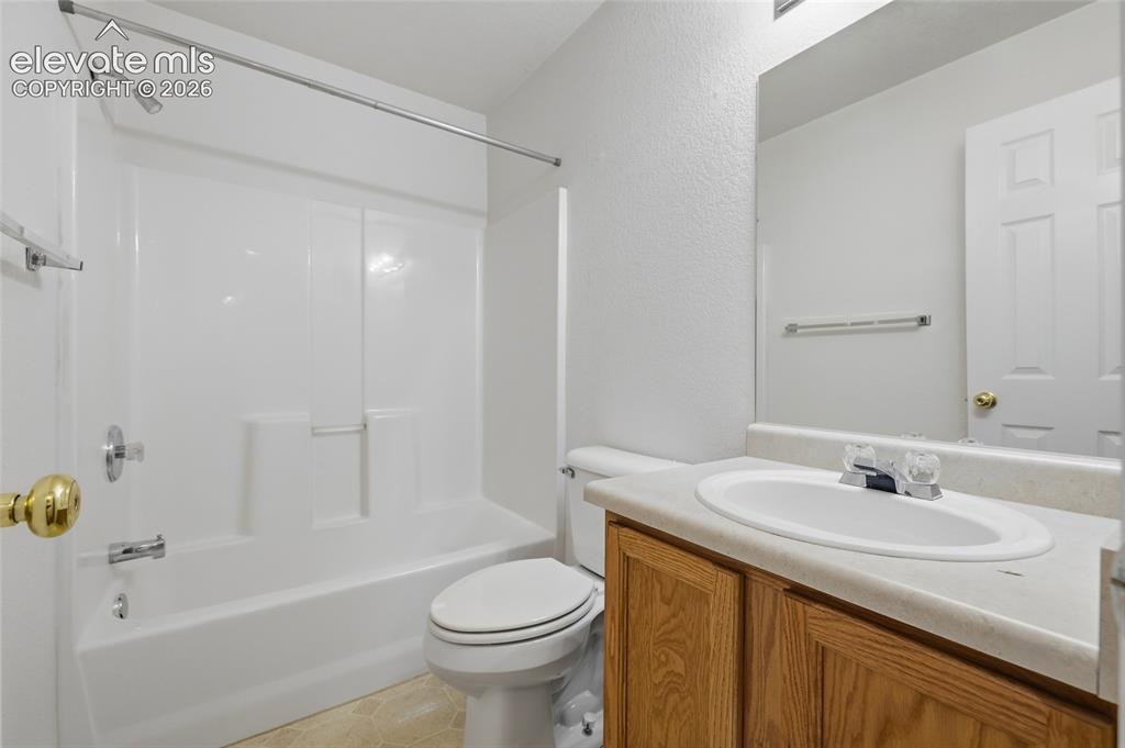 Image 30 of 45: Full bathroom featuring a single vanity with wood-finish cabinetry, an inte