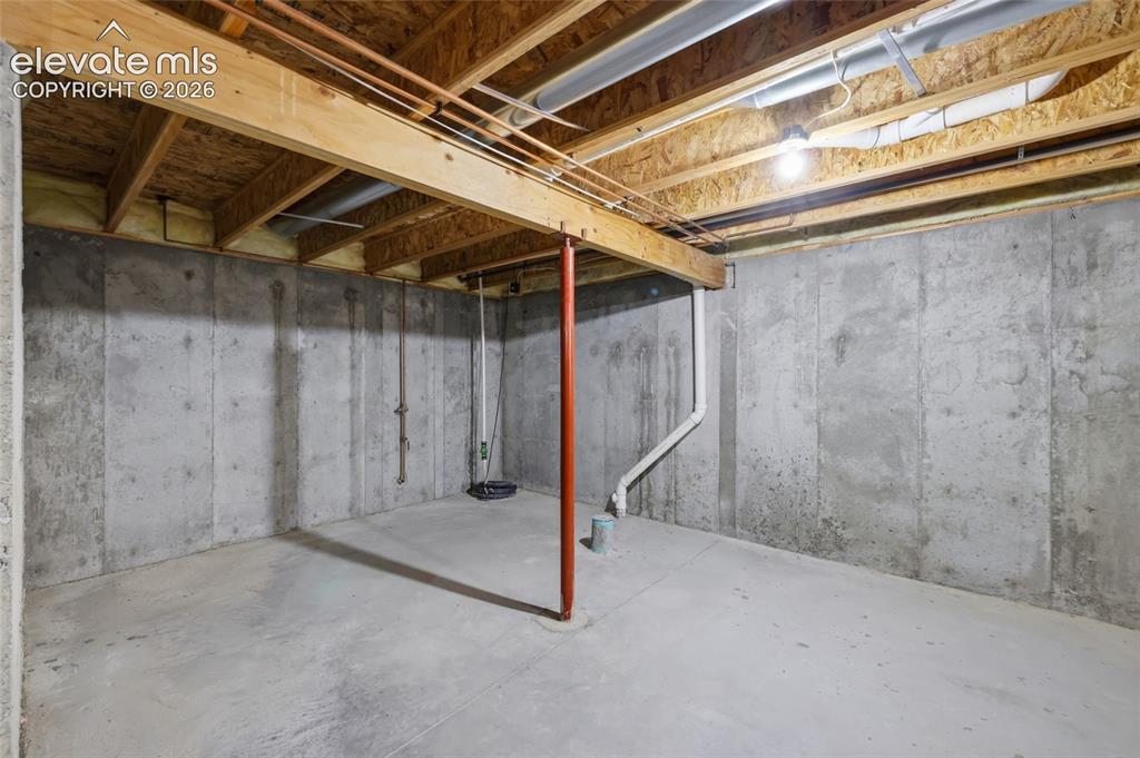 Image 32 of 45: Unfinished basement with concrete walls and flooring, exposed wood ceiling