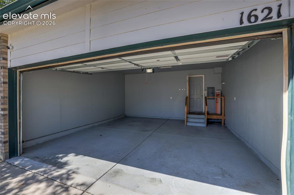 Image 36 of 45: Two-car garage with concrete flooring, painted interior walls, and an inter