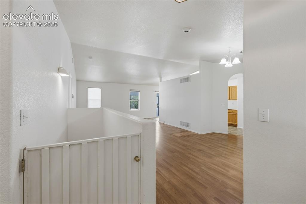 Image 4 of 45: Open concept living area with wood-finish flooring, white walls, and recess