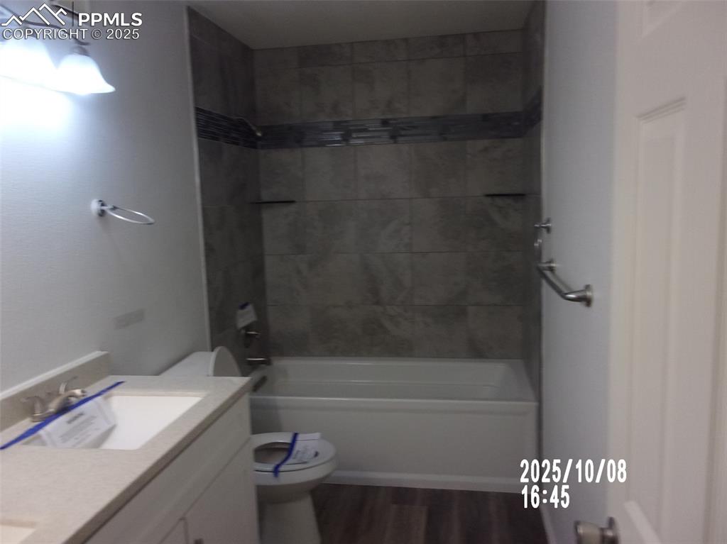 Image 11 of 13: Full bathroom featuring shower / tub combination, vanity, and dark wood fin