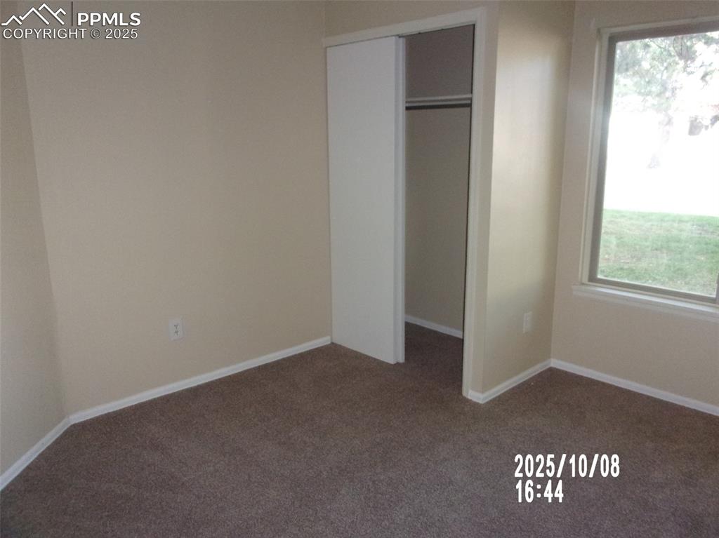Image 6 of 13: Unfurnished bedroom featuring dark carpet and a closet