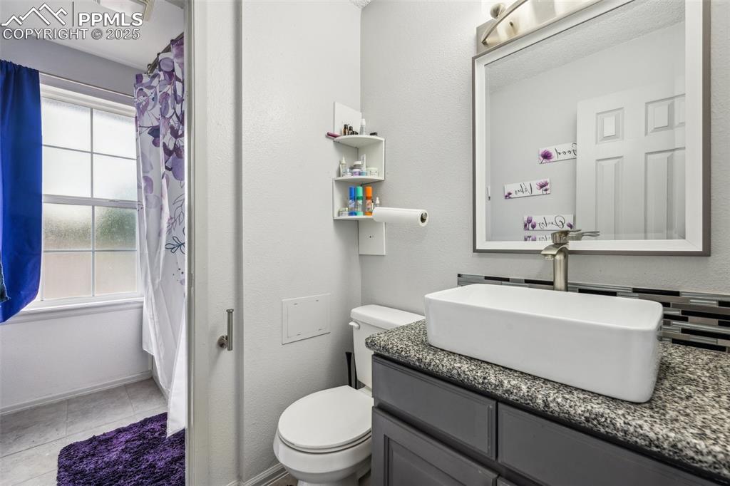 Image 13 of 19: Upper-level full bath with updated vanity and modern tilework.