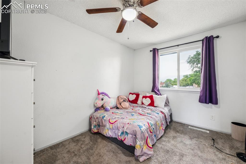 Image 14 of 19: Bedroom 2 with newer carpet, closet space, and ceiling fan.