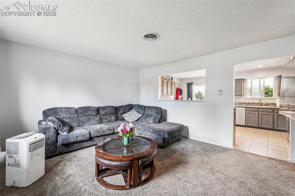 Image 3 of 19: Bright main-level living room with large windows and an open feel.