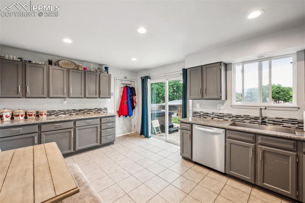 Image 4 of 19: Stylish kitchen with updated cabinetry, tile flooring, and stainless steel 