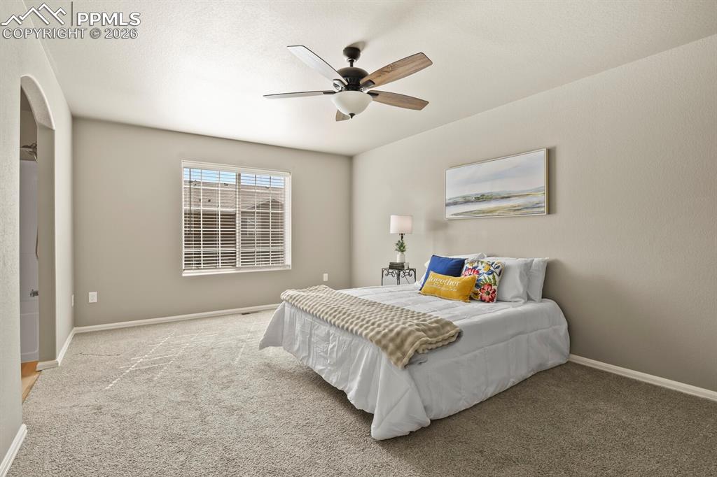 Image 13 of 27: This room features neutral-toned walls and carpet flooring, a window with b