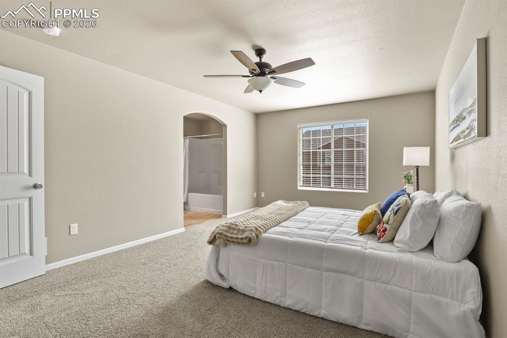 Image 16 of 27: Well-appointed room featuring carpet flooring, a ceiling fan, and a window 