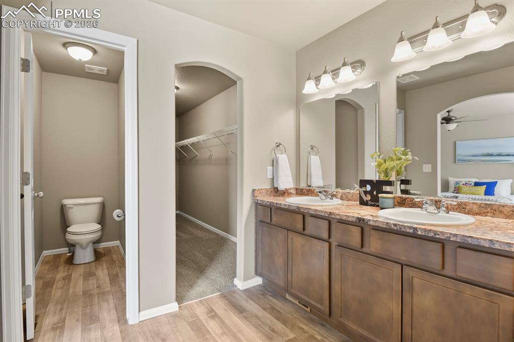 Image 18 of 27: The bathroom features a double vanity with two sinks and two mirrors, a toi