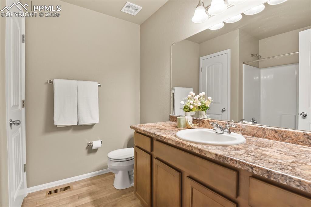 Image 22 of 27: Bathroom featuring a vanity with a counter-mounted sink, a large mirror, an