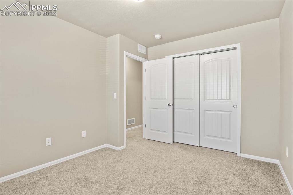 Image 25 of 27: This room features neutral-toned walls, light-colored carpeting, and white 