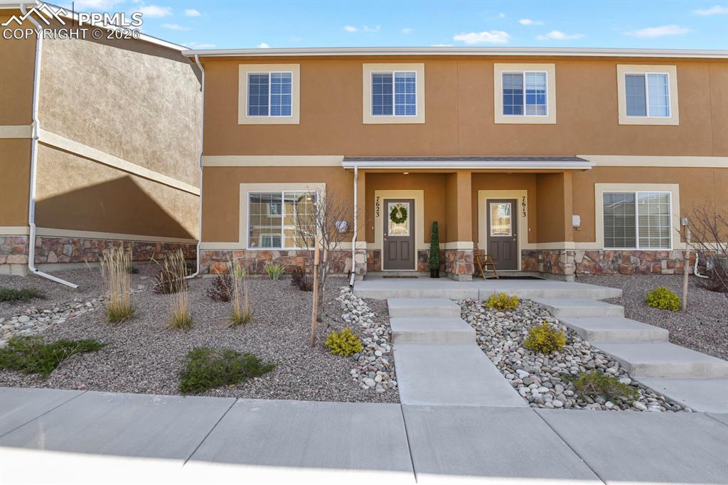 Image 3 of 27: The property features a stucco exterior with stone accents, offering a dura