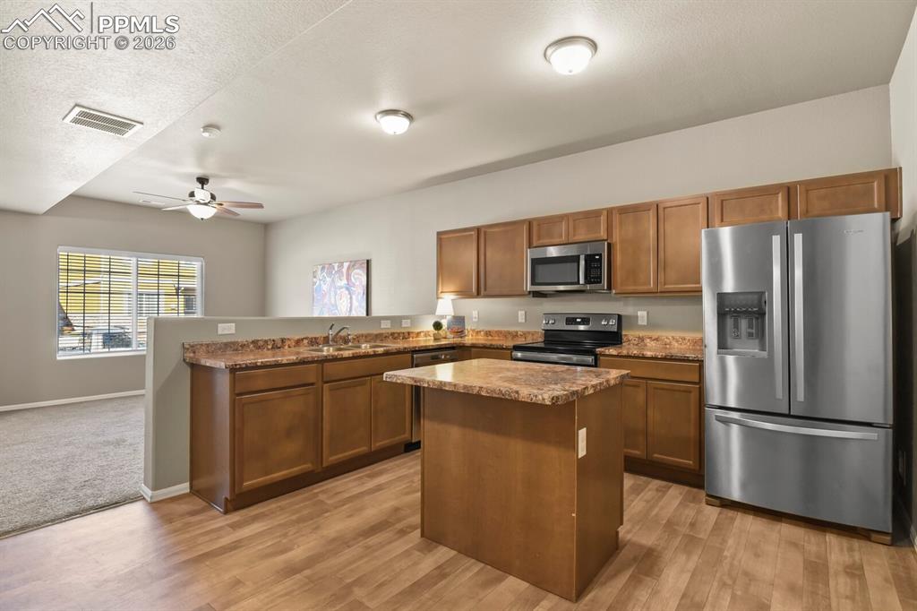 Image 7 of 27: The kitchen features wood cabinetry, granite countertops, and stainless ste