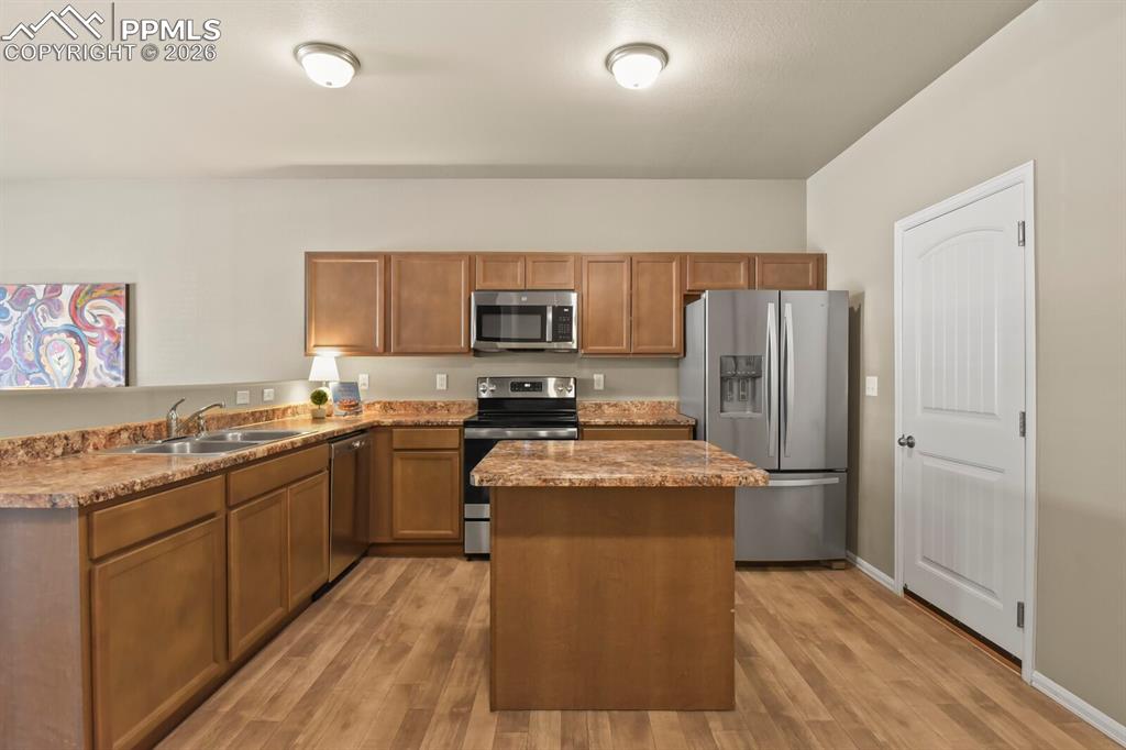 Image 9 of 27: The kitchen features wood cabinetry, granite countertops, stainless steel a