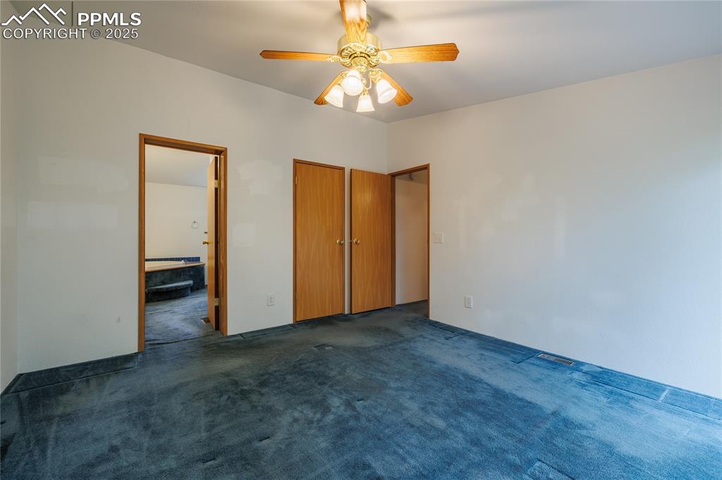 Image 14 of 26: Unfurnished bedroom with carpet flooring, ensuite bathroom, and a ceiling f