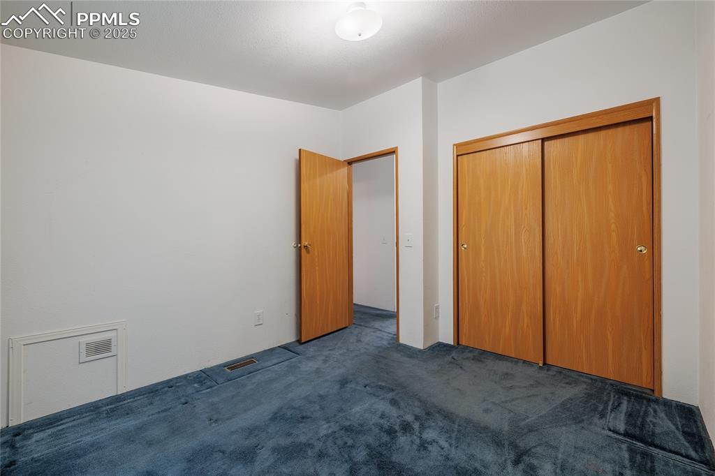 Image 18 of 26: Unfurnished bedroom with carpet flooring and a closet