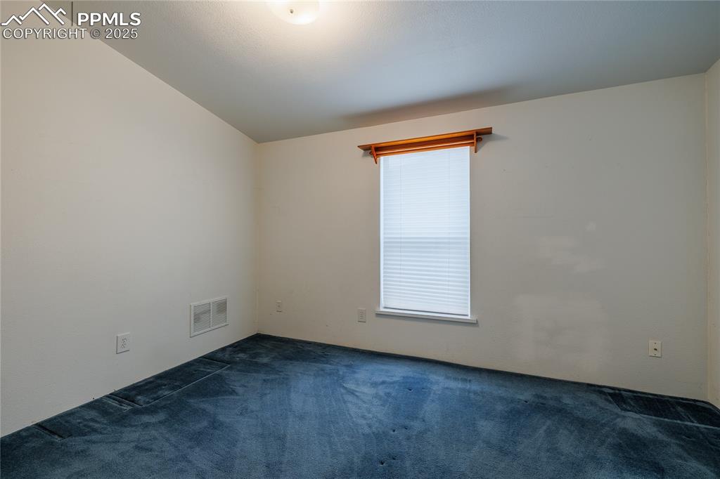 Image 19 of 26: Carpeted spare room with plenty of natural light and vaulted ceiling