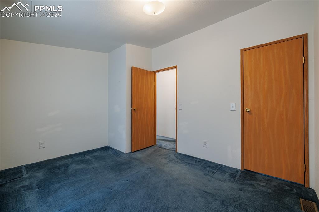 Image 20 of 26: Unfurnished bedroom with carpet flooring